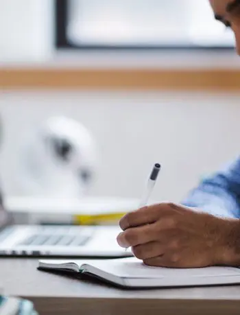 Man writing with laptop